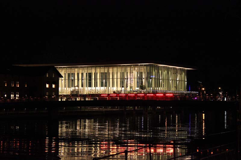 Halmstads stadsbibliotek vid vattnet en klar kväll med reflektion