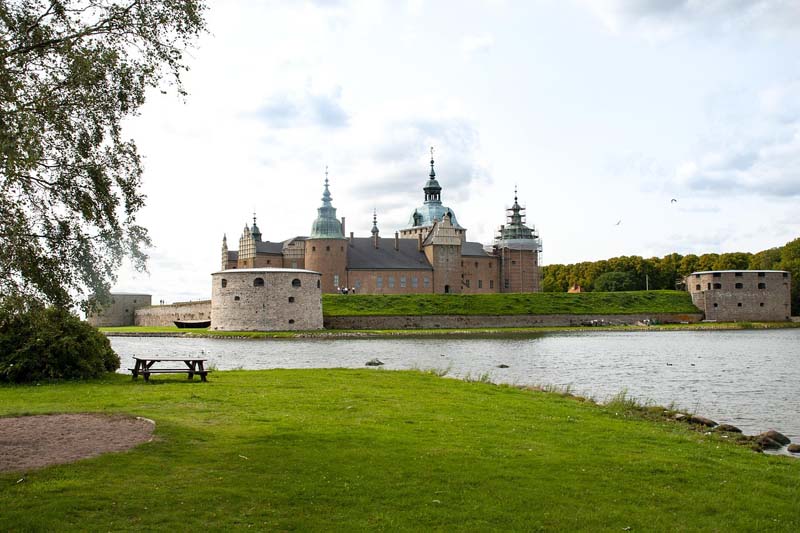 Kalmar slott vid vattnet omgivet av grönska en sommardag