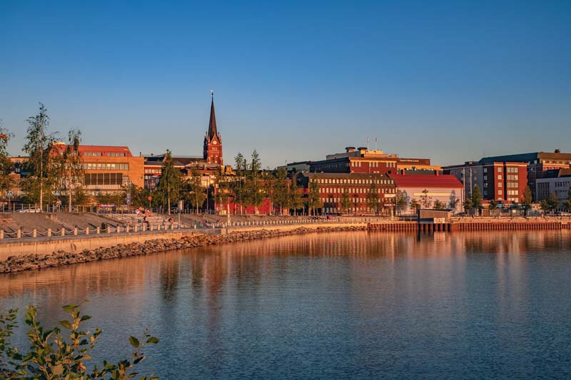 Kvällsljus över Luleå centrum med kyrktorn vid vattnet