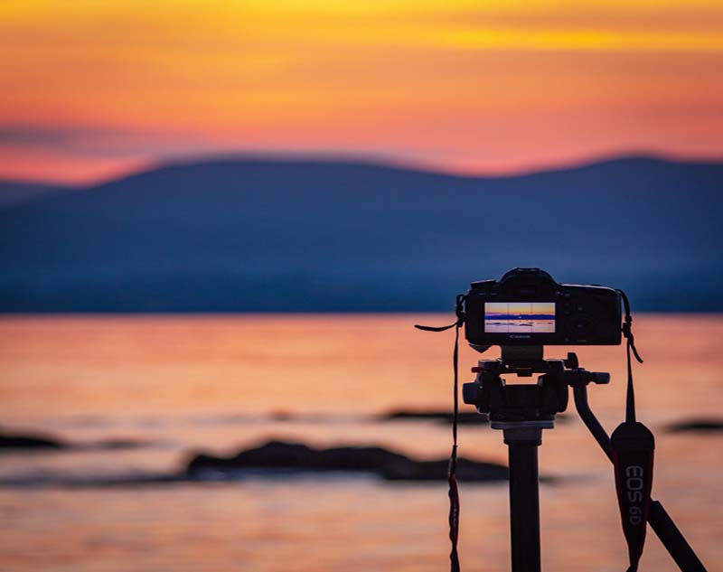 Kamera på stativ vid solnedgång, exempelbild för fotograf hemsida